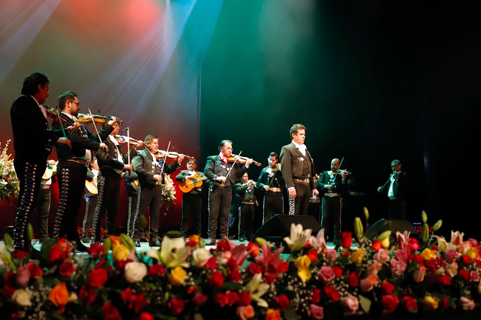 A mariachi band performing on stage with violins and trumpets