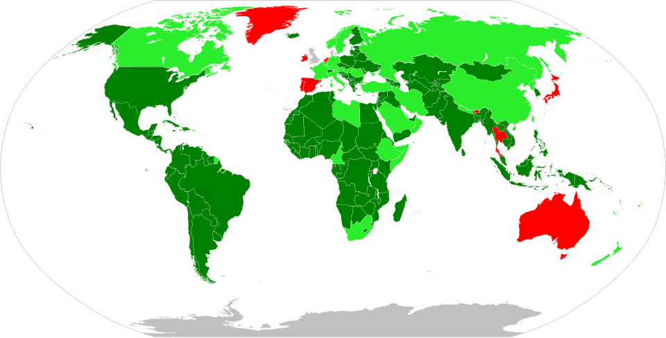A marching band of students in red, white and blue uniforms parading through a Panamanian town