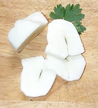 Golden-brown slices of grilled halloumi cheese on a white plate with lemon